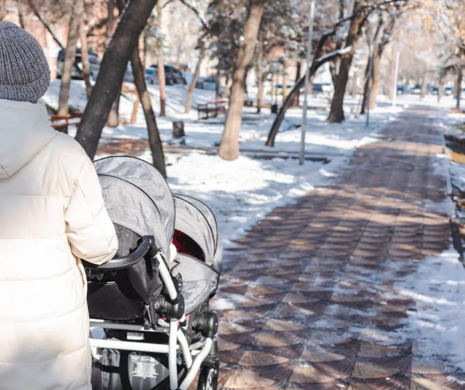 Mamă ținând în brațe bebeluș în haină de iarnă – Bebes.ro